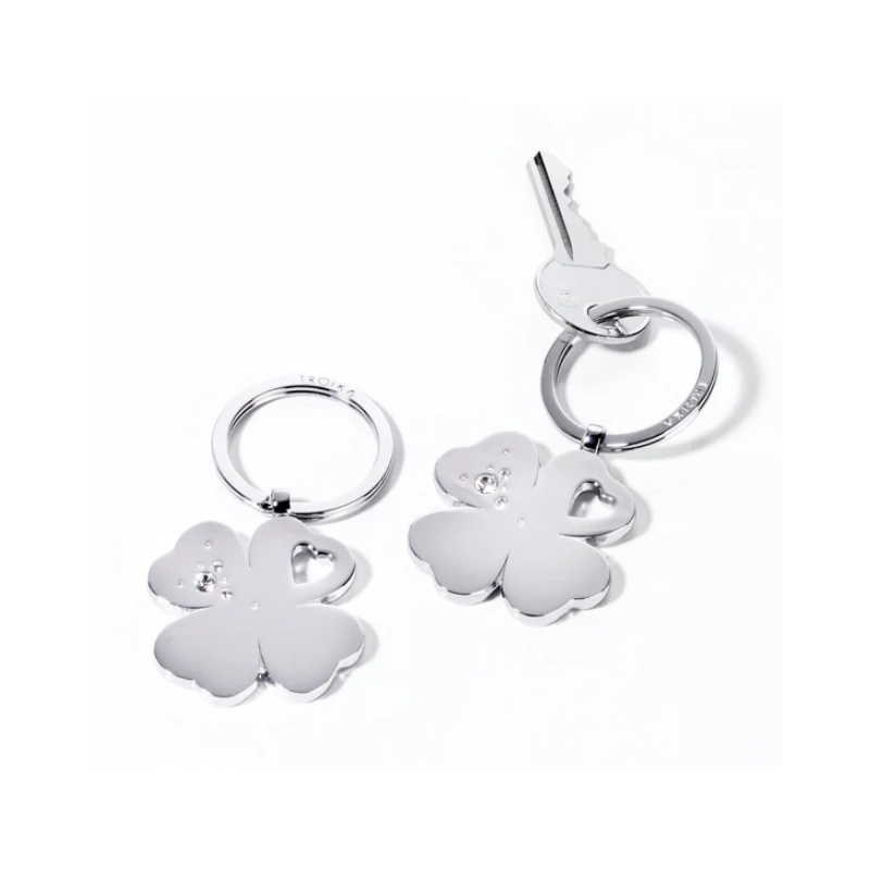 Two silver keychains with clover and heart designs on a white background